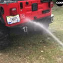 Dog Tries To Catch Water From Hose While Owner Washes Jeep